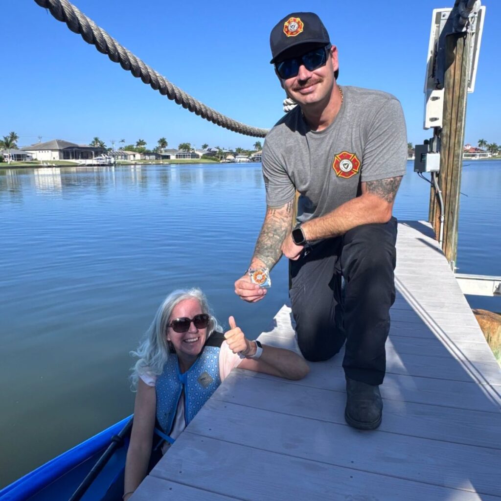 man on a dock and a woman in a kayak