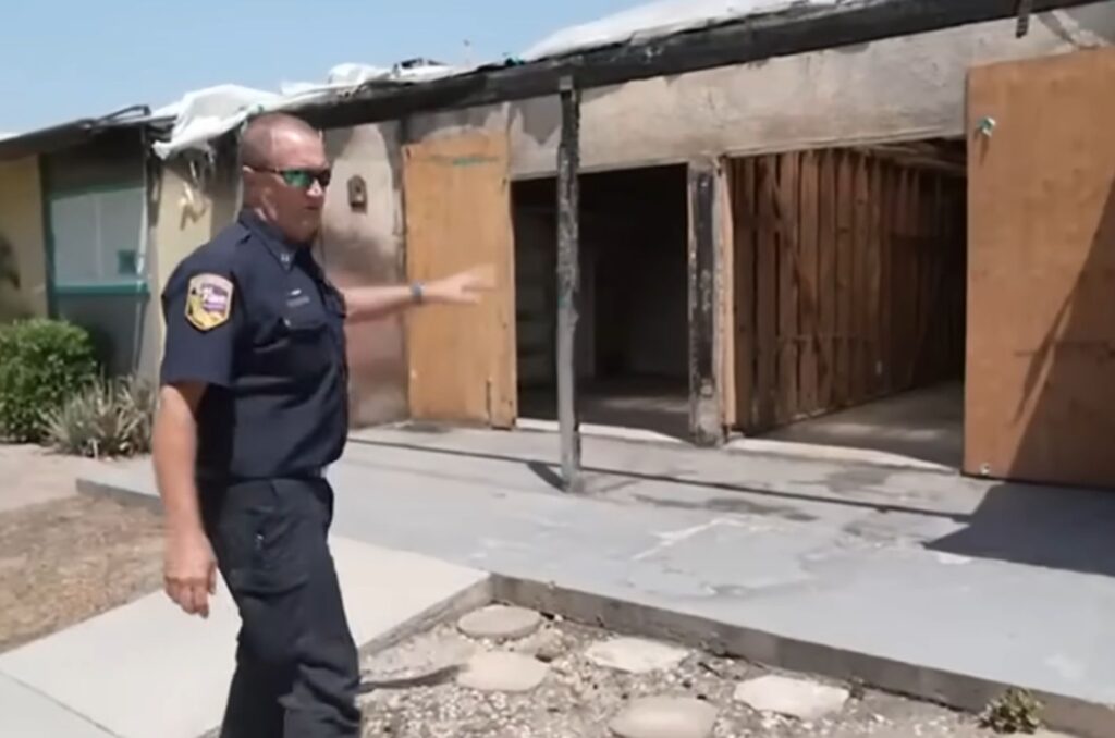 firefighter pointing to a burned apartment