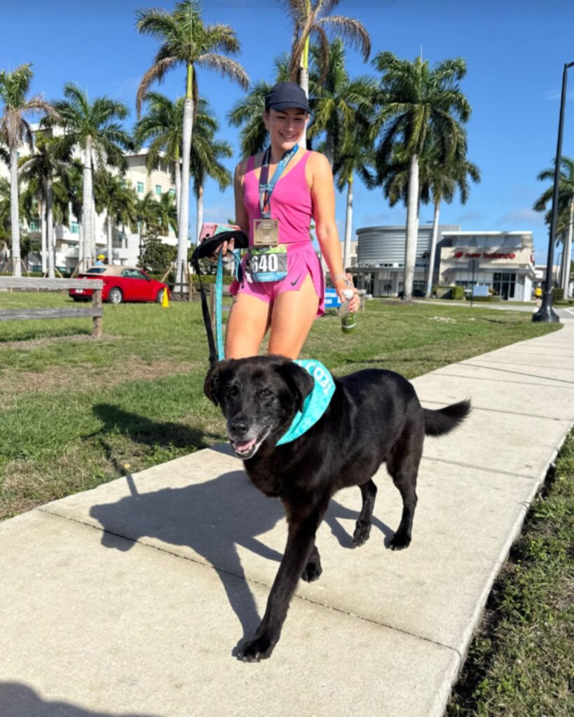 woman walking a black dog on a leash