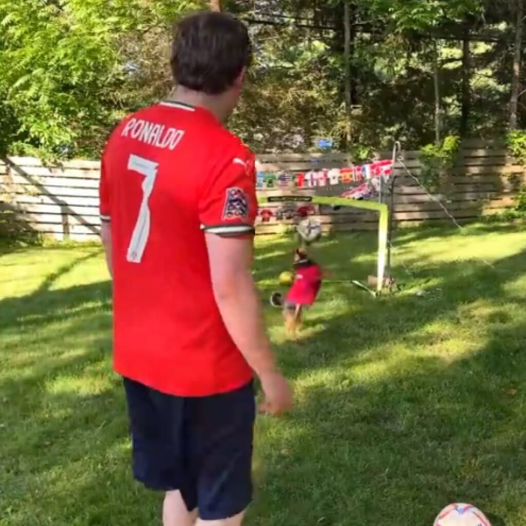 man shooting a ball to a dog