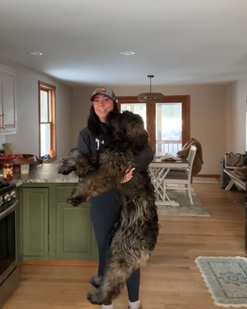 woman posing with a giant dog in her hands