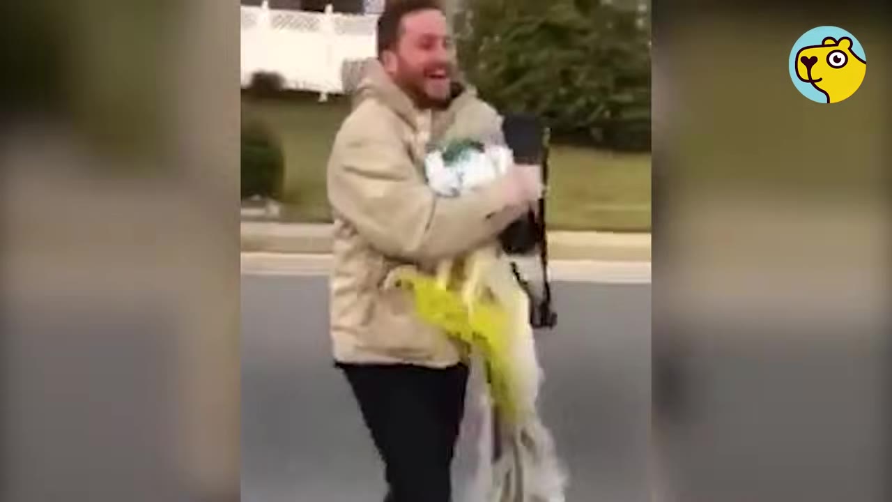 A smiling man carrying a captured peacock wrapped in a yellow net.