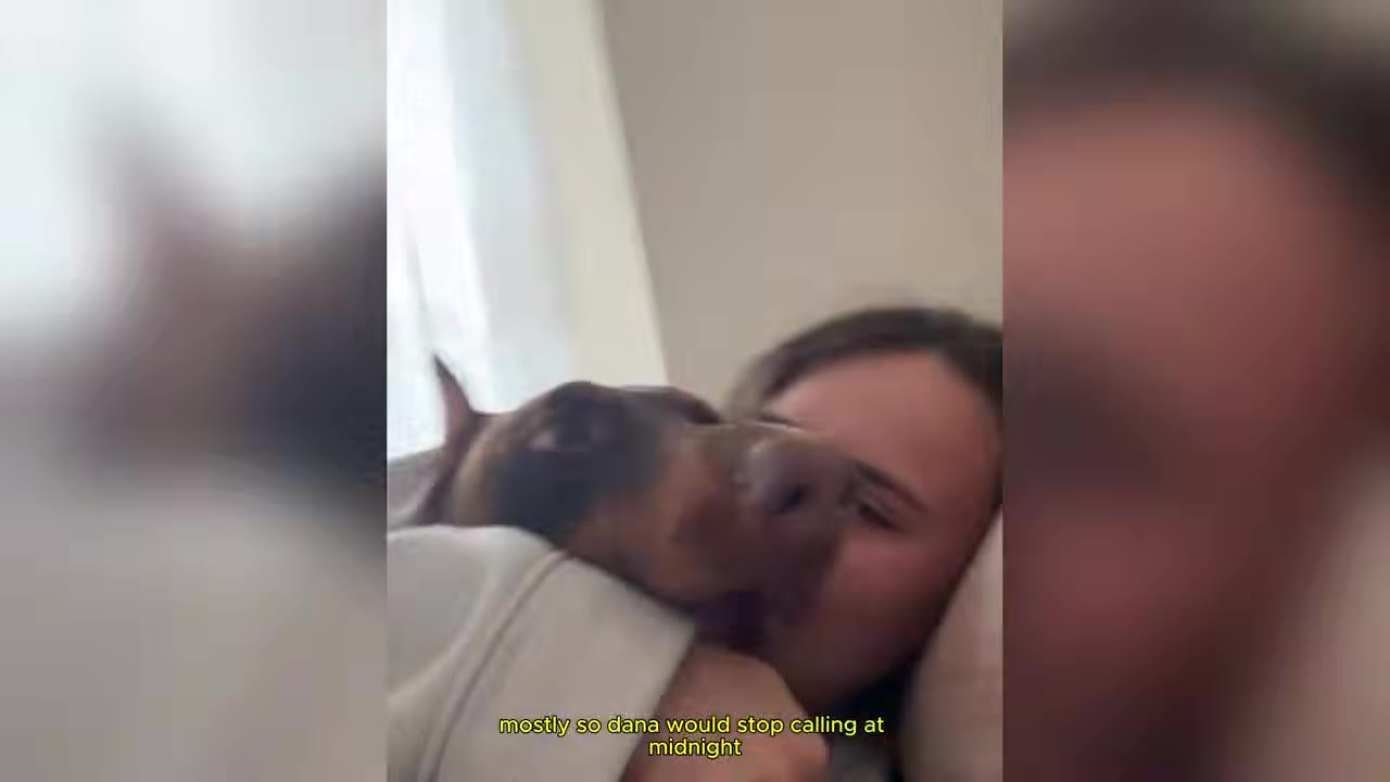 A woman lying down in bed with a brown Doberman dog resting its head on her shoulder, with a subtitle that reads 'mostly so dana would stop calling at midnight'.