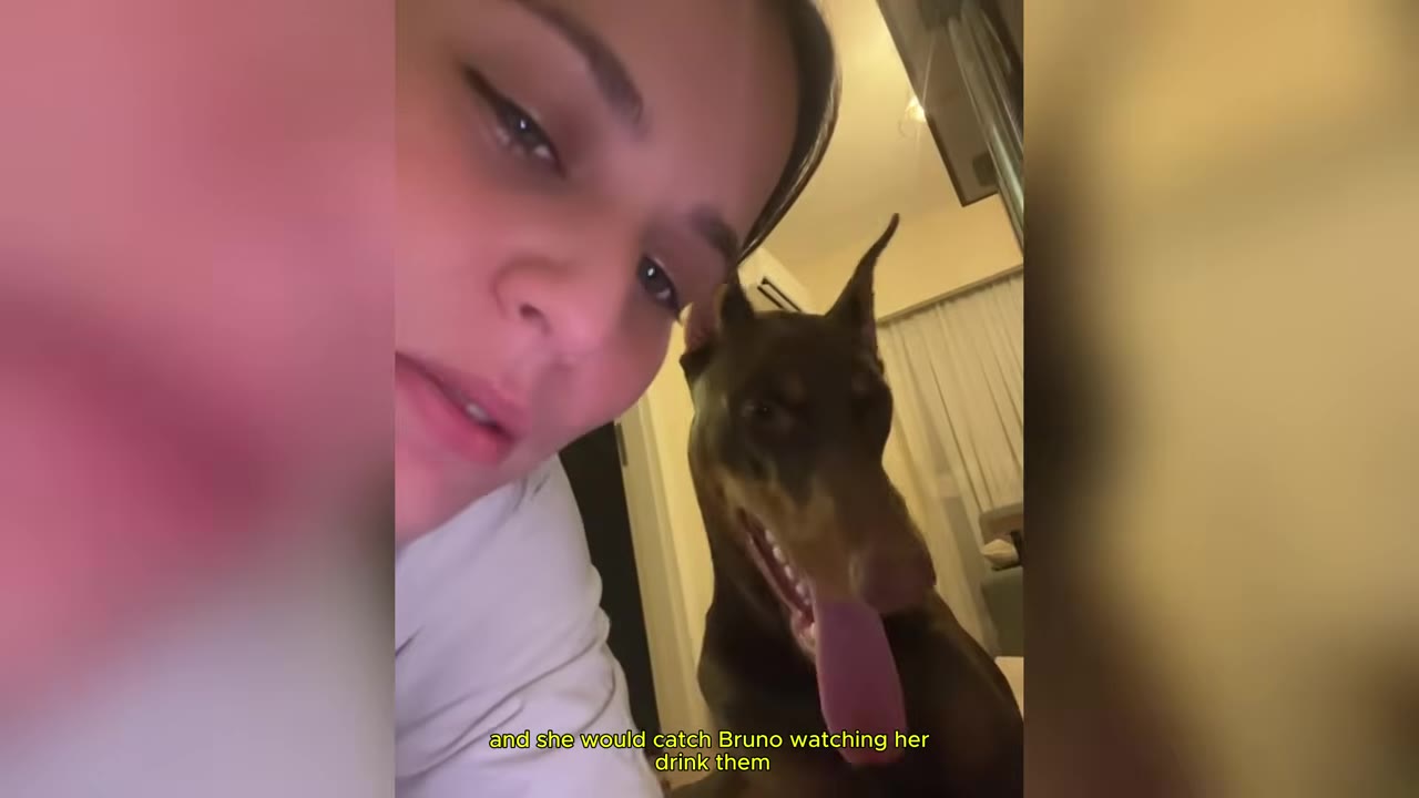 A close-up of a tearful woman looking at the camera with her Doberman dog sitting close behind her.
