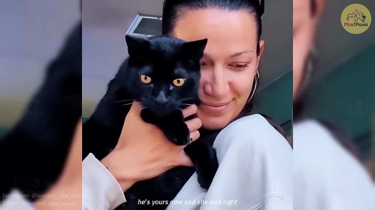 A smiling woman with dark hair pulled back holding a black cat with yellow eyes close to her chest.