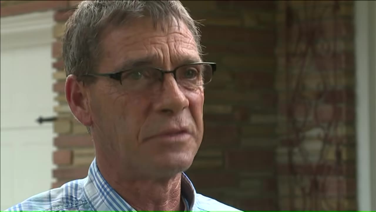 A close-up shot of a man with glasses looking thoughtful and concerned.
