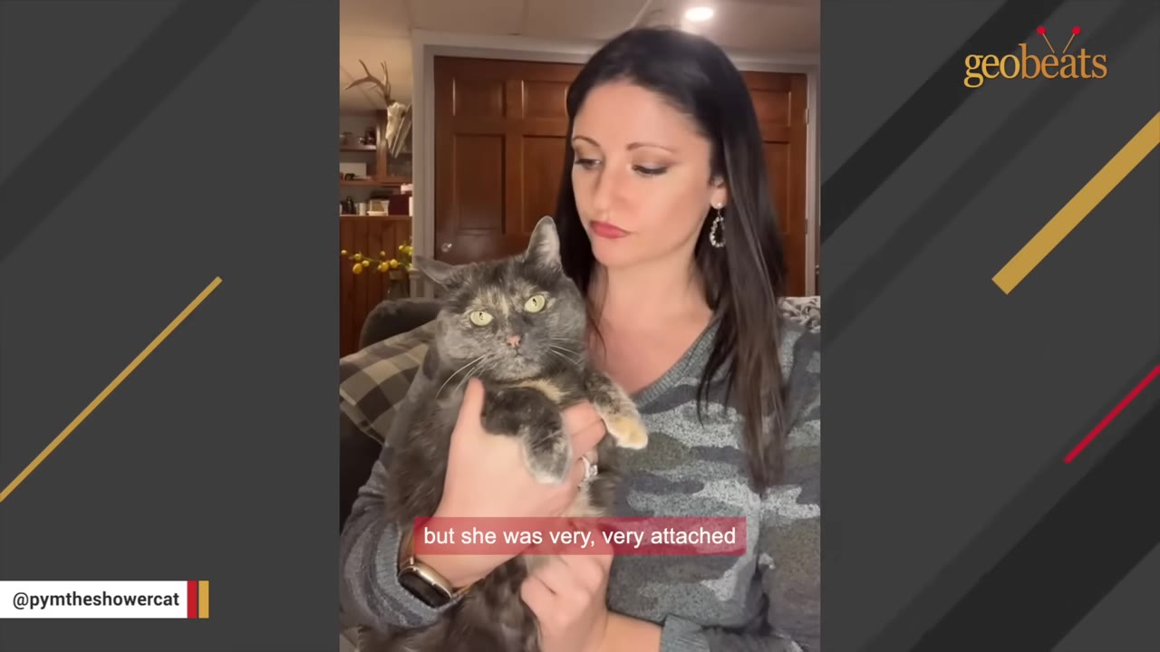 A woman with long dark hair holds a fluffy grey and tan tortoiseshell cat in her arms.