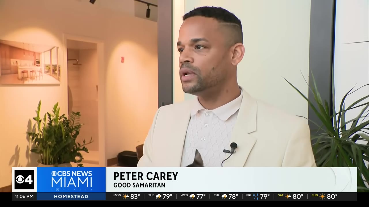 A medium close-up shot of Peter Carey, identified as a Good Samaritan, speaking during an interview with a serious expression.