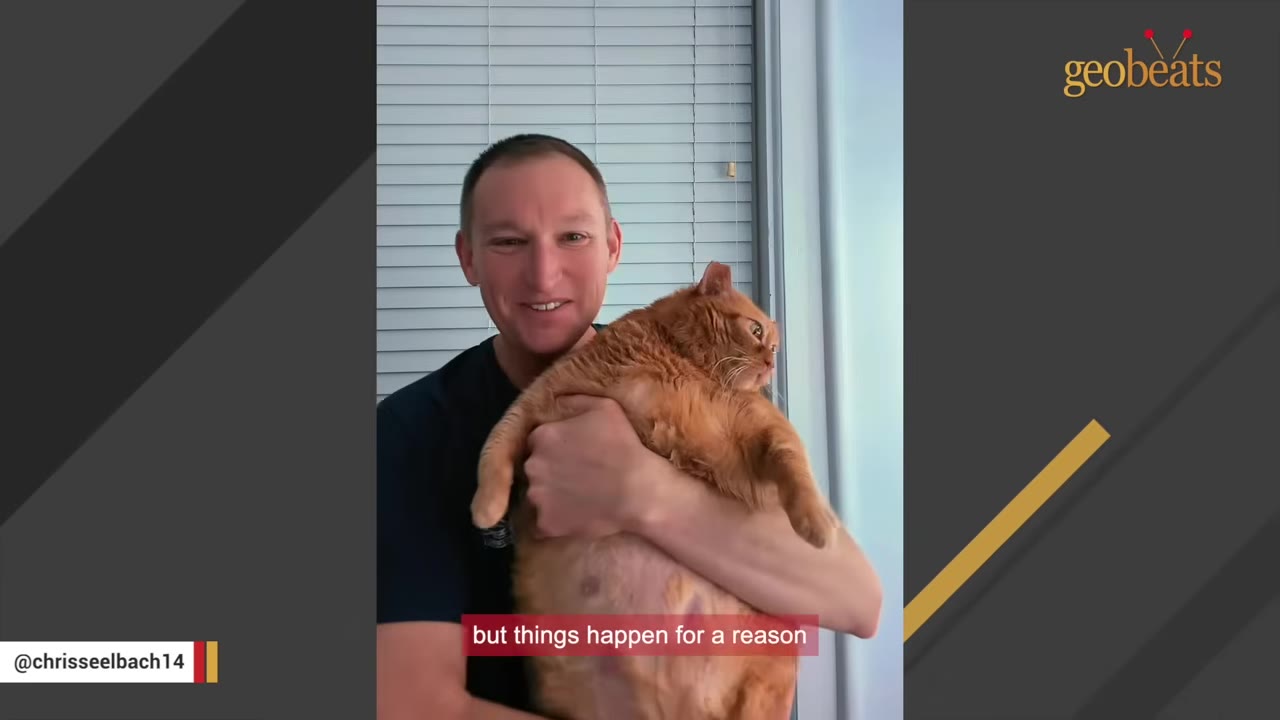 A smiling man holds a large, overweight orange cat in his arms.