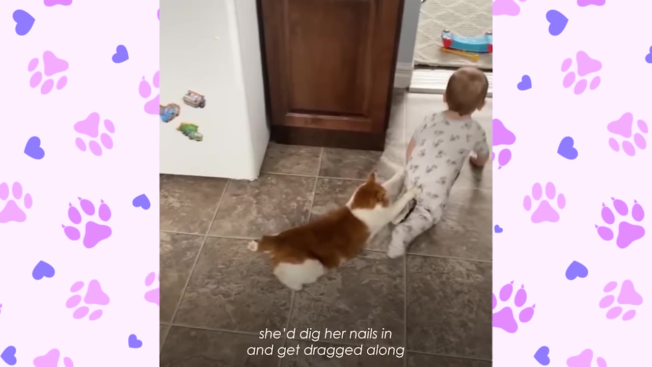 An orange and white cat holds onto the back of a crawling baby's patterned pajamas with its front paws on a tiled floor.